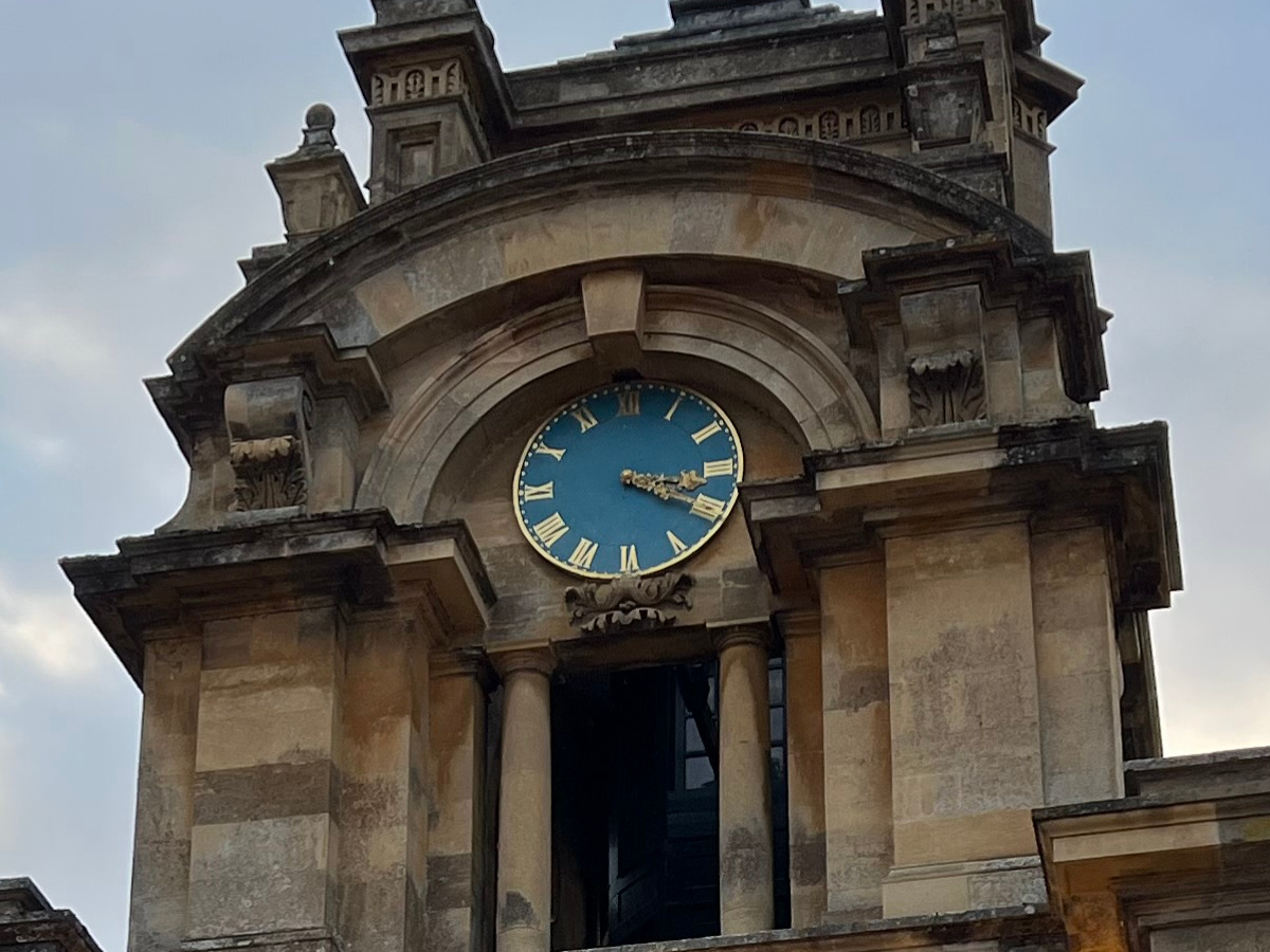 Crop of stone clock tower with blue clock shot on Apple iPhone 13 Pro Max