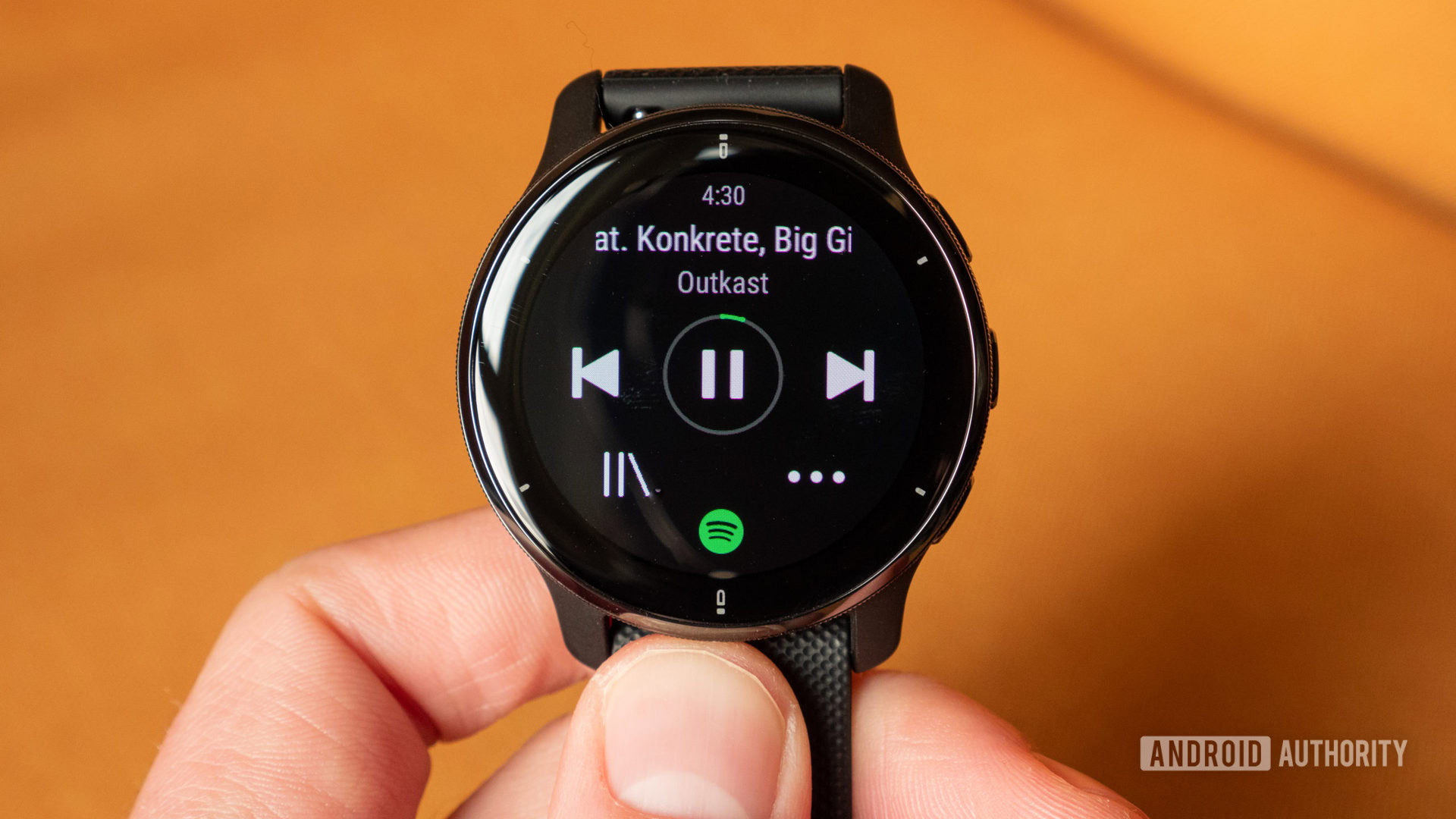 A Garmin Venu 2 Plus in hand displays a user Spotify offline downloads.