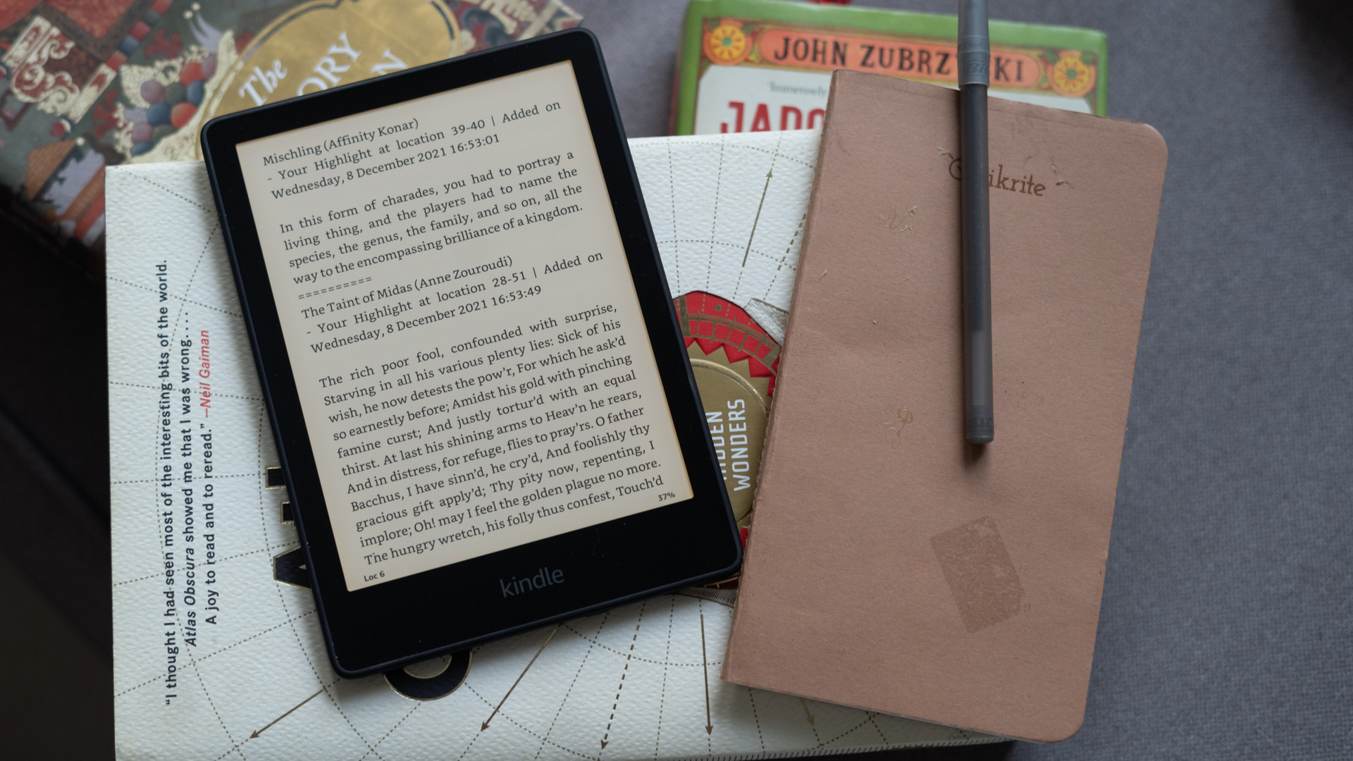 Kindle Paperwhite 2021 showing the notes clippings page next to a notebook