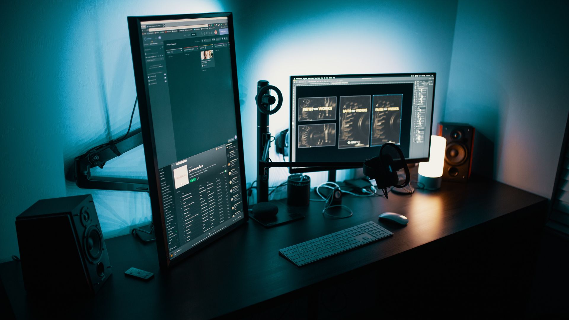 A desk with a multi monitor setup, including one vertical monitor.