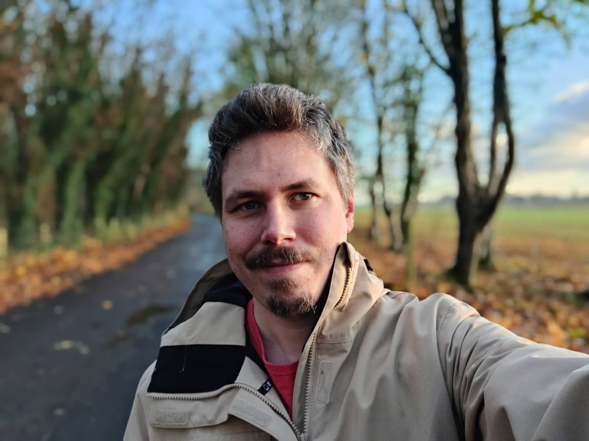 Outdoor selfie on a cold day with trees in the background shot on OnePlus 9 Pro