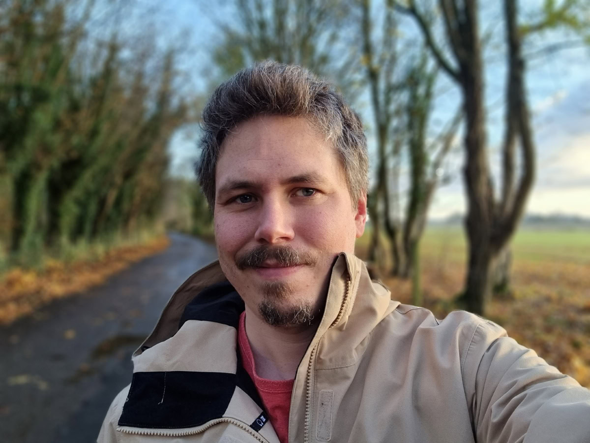 Outdoor selfie on a cold day with trees in the background shot on Samsung Galaxy S21 Ultra
