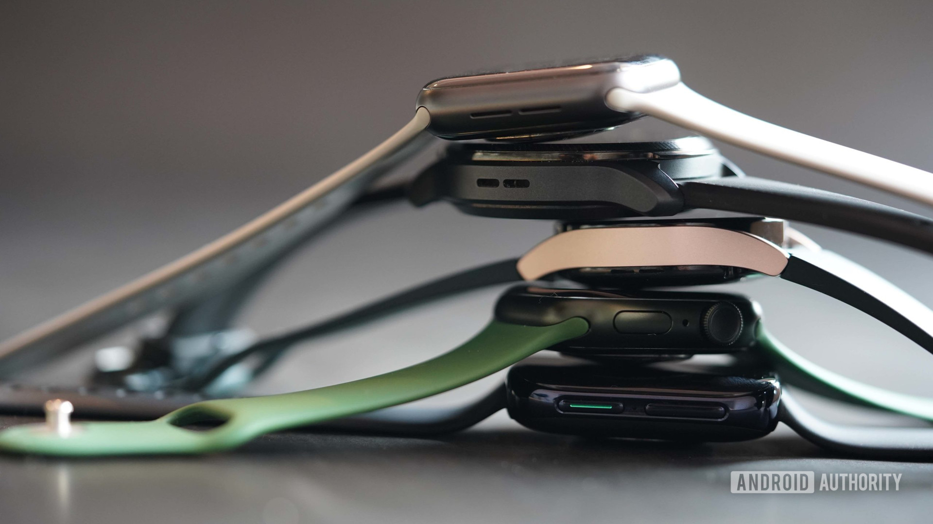 A stack of smartwatches includes an Apple Watch Series 6 and 7, as well as a Galaxy Watch 4, an Oppo Watch and a TicWatch Pro 3 Ultra. 