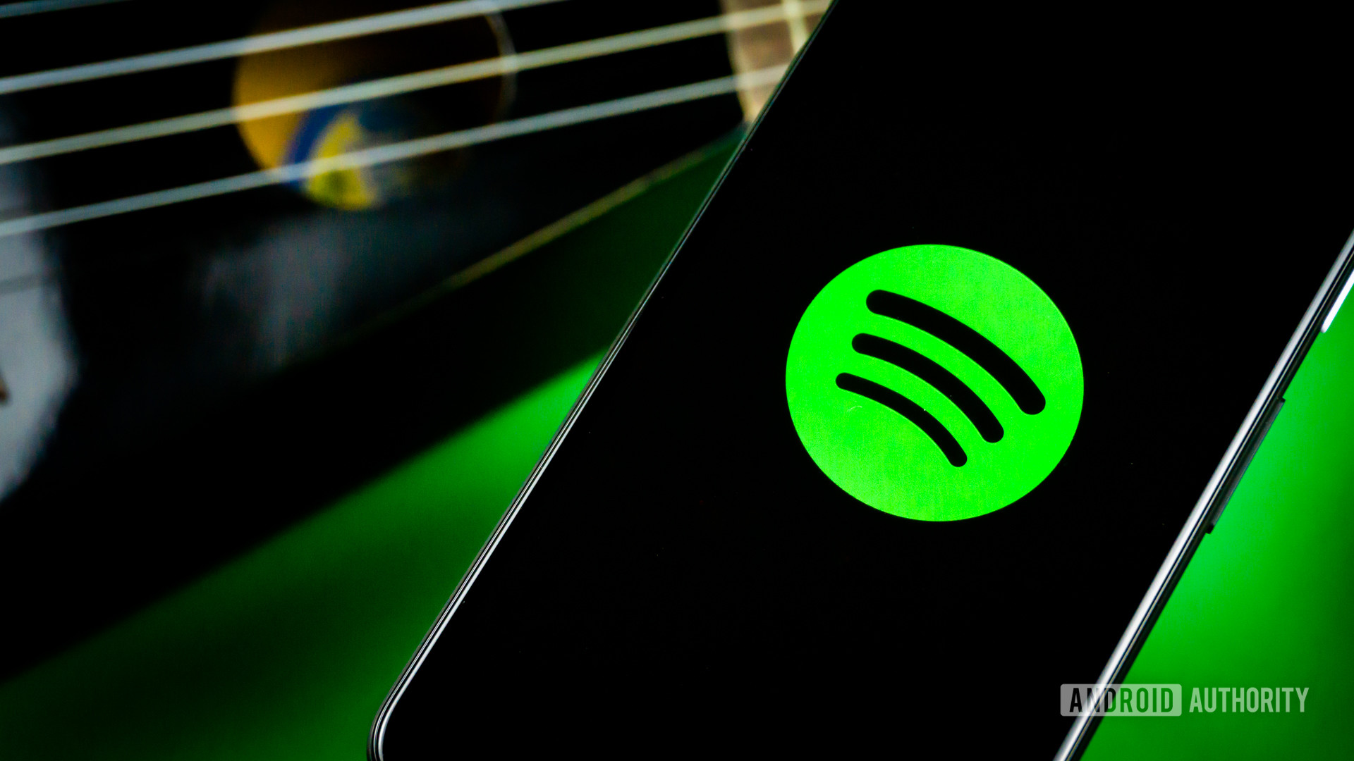 Spotify em um telefone ao lado de uma guitarra