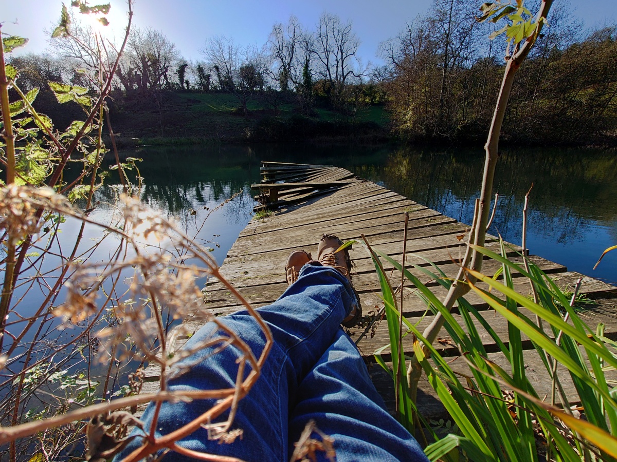Wide-angle picture of legs relaxing on sunny wooden dock shot on Sony Xperia 1 III
