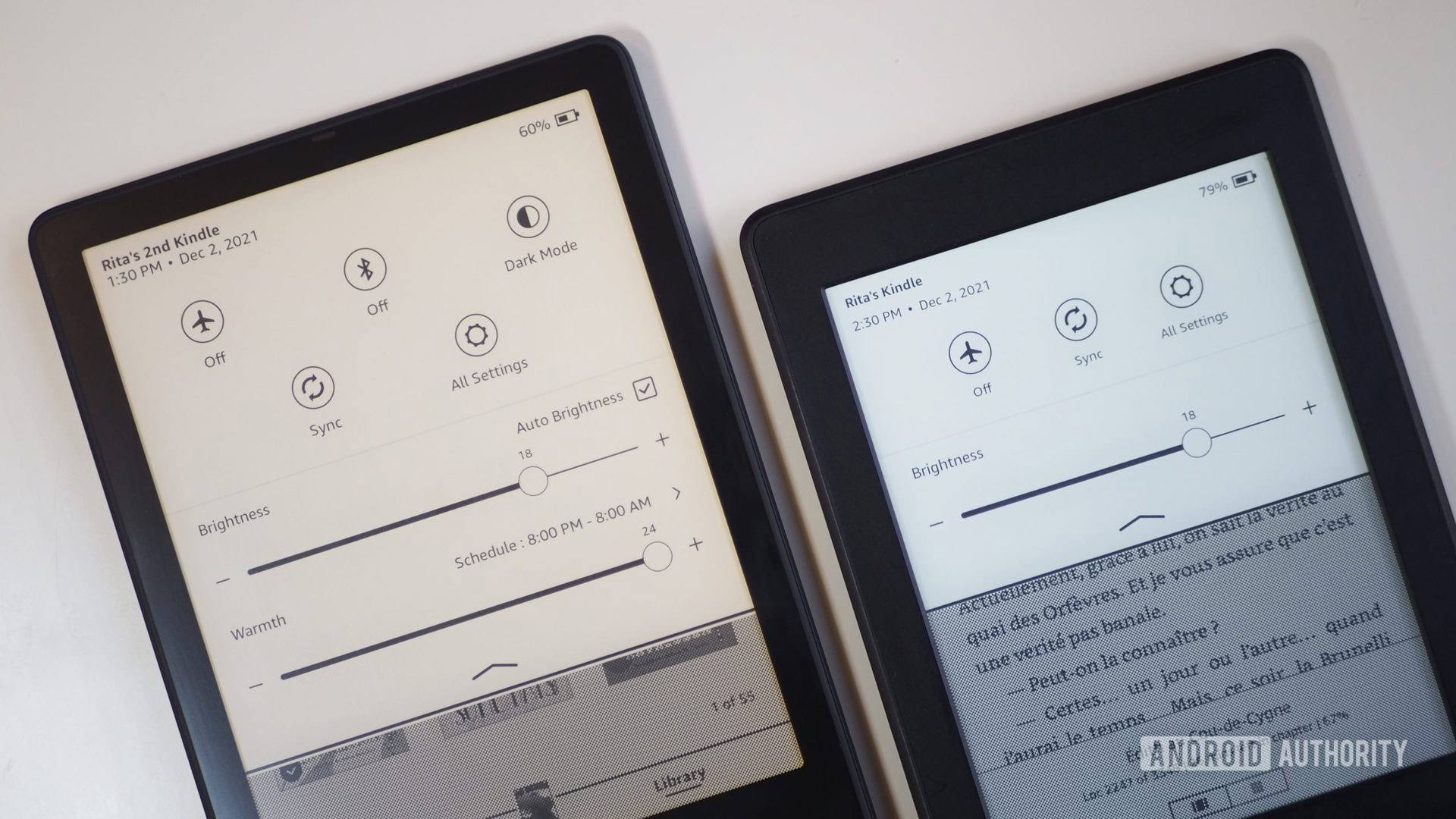 Amazon Kindle Paperwhite 2021 next to Paperwhite 2015, laying on a table, showing the drop-down settings and different display temperature warmth