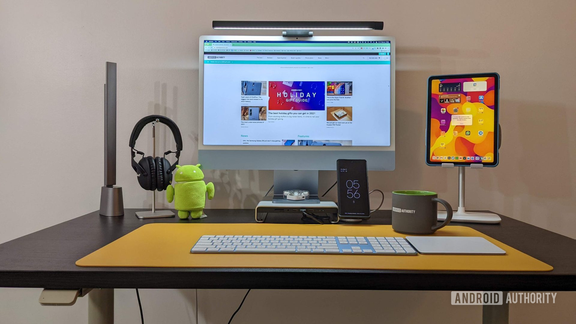 Ikea Idasen sit-stand desk with M1 iMac 2021, iPad Air 4 2020, Pixel 6 Pro, Android plush, Marshall Monitor II ANC, yellow desk mat, Sateshi USB-C hub monitor stand, and more