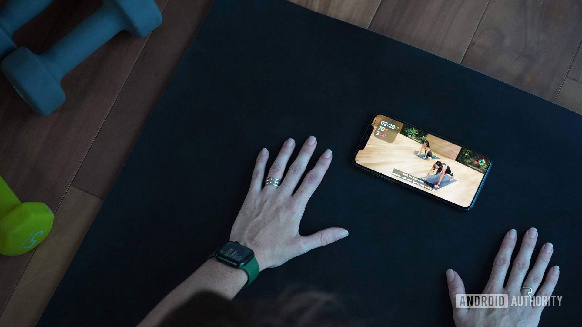 A woman wearing an Apple Watch works out following a class on Apple Fitness Plus.