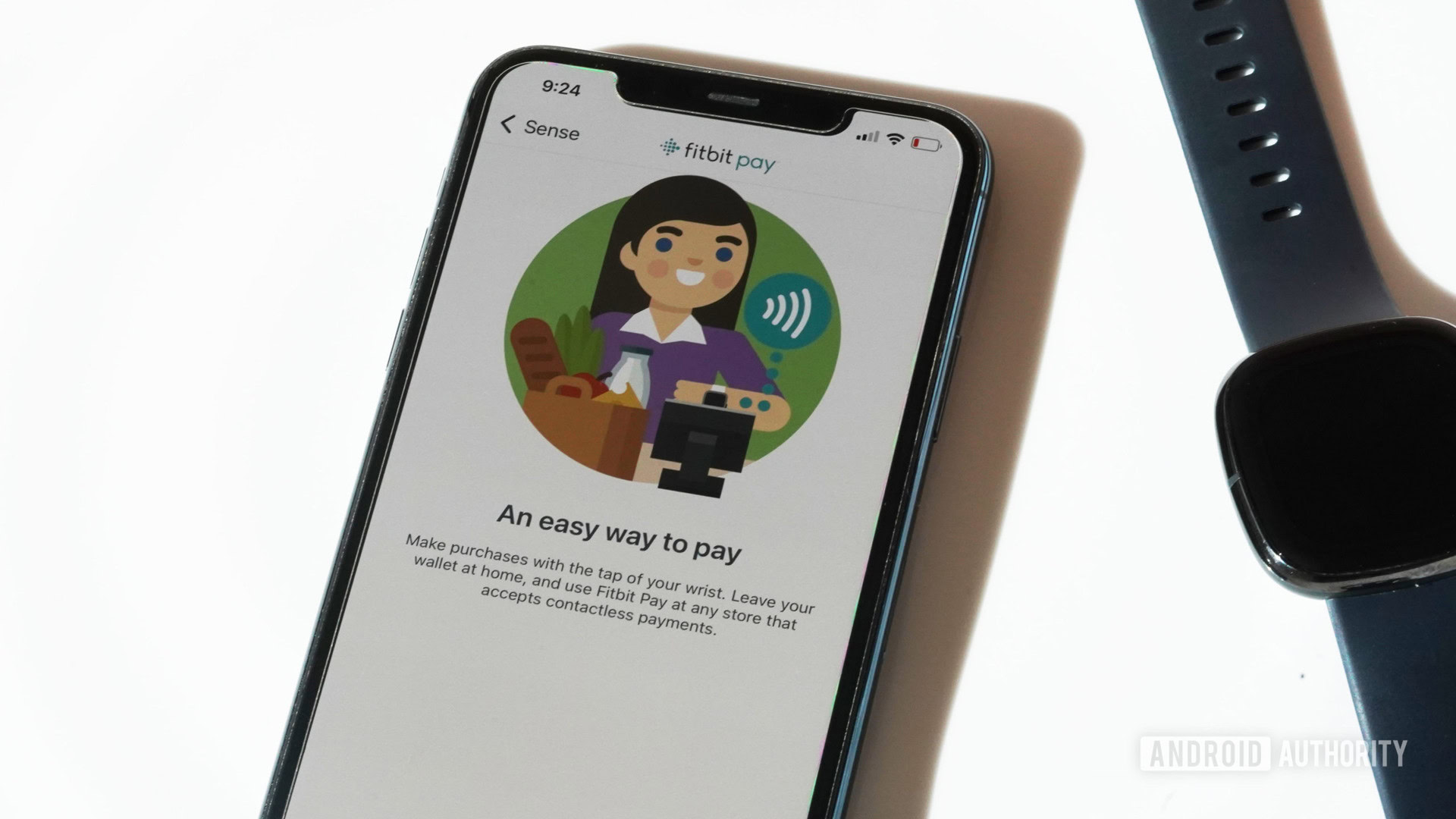 An iPhone 11 displays the Fitbit Pay screen in the Fitbit App, along side a Fitbit Sense.