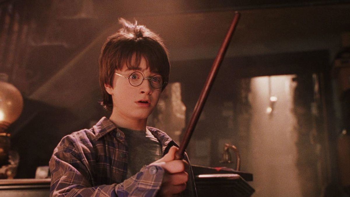 Harry Potter memegang tongkat sihir di Harry Potter and the Philosophers Stone - film merak terbaik