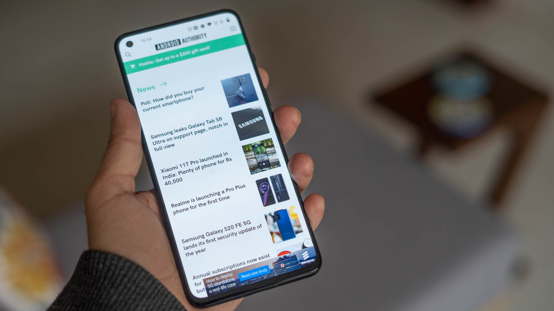 OnePlus 9RT in hand with the android authority page