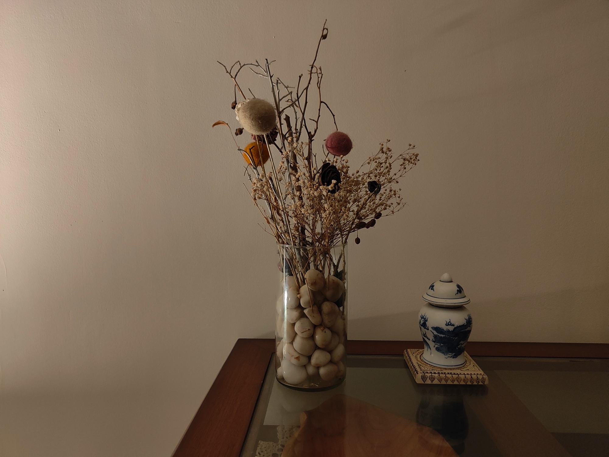 OnePlus 9RT low light regular camera shot of a table with a vase filled with pebbles and dried flowers
