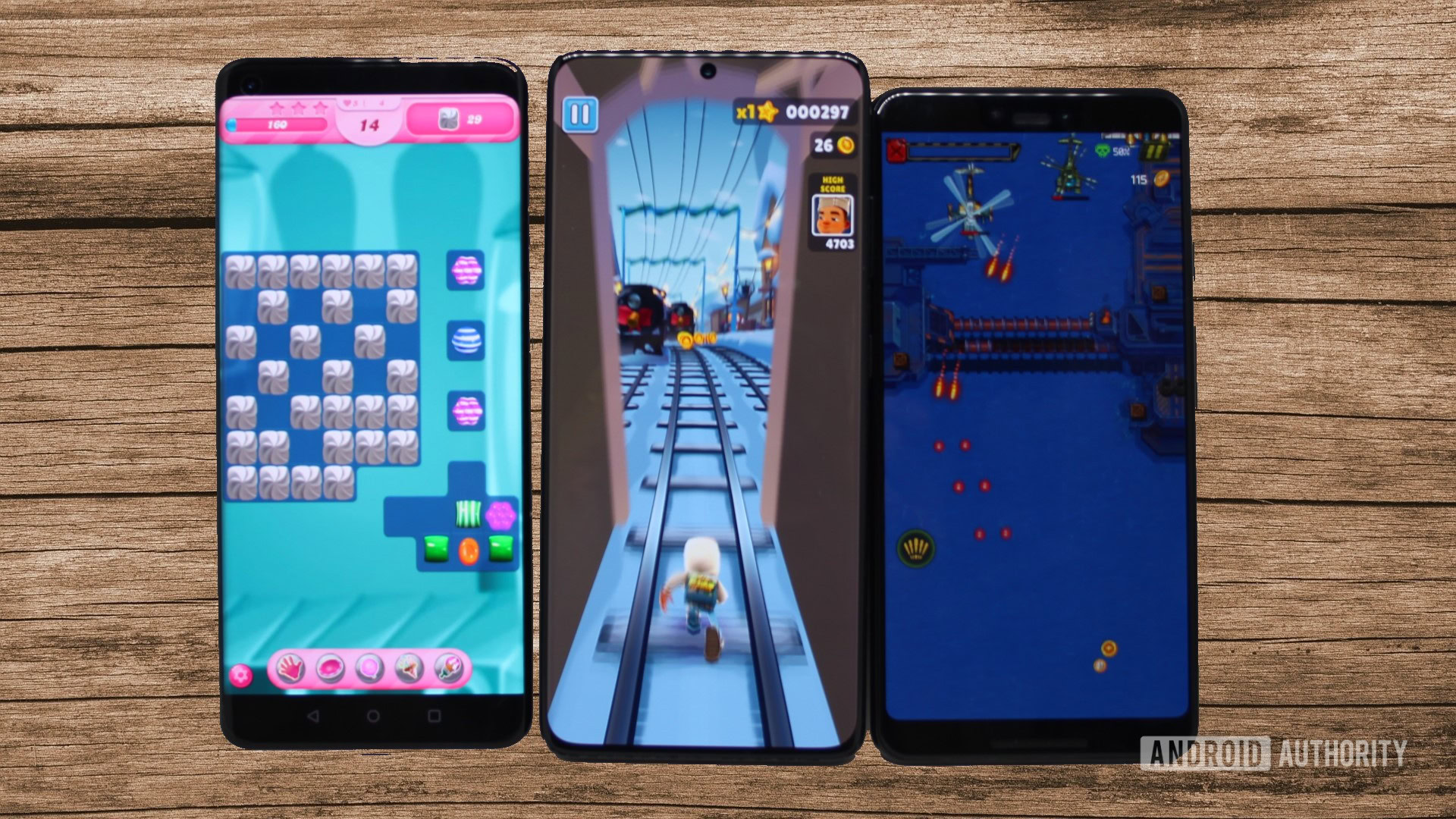 Tres teléfonos Android que ejecutan tres juegos con un fondo de panel de madera