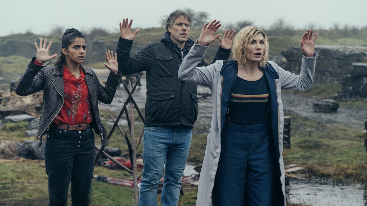 Jodie Whittaker and her companions with arms raised in Doctor Who