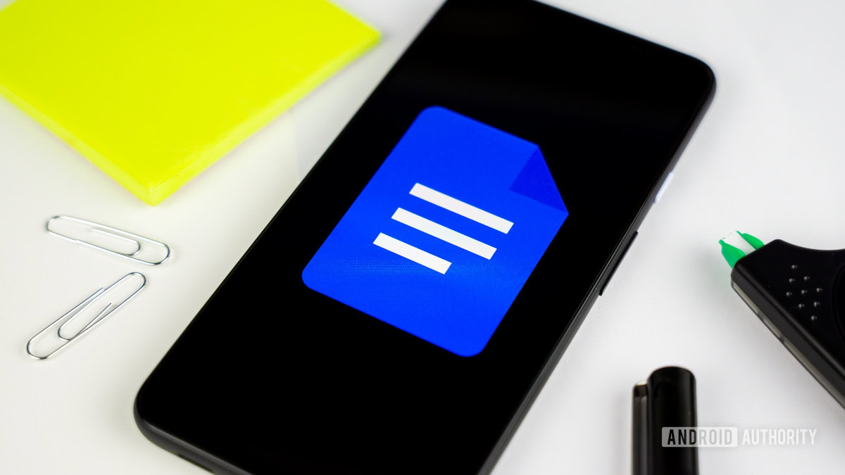Google Docs logo on smartphone next to office gear stock photo 2