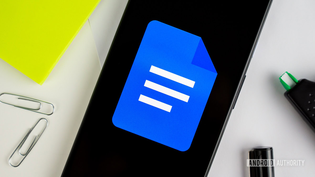 Google Docs logo on smartphone next to office gear stock photo 3