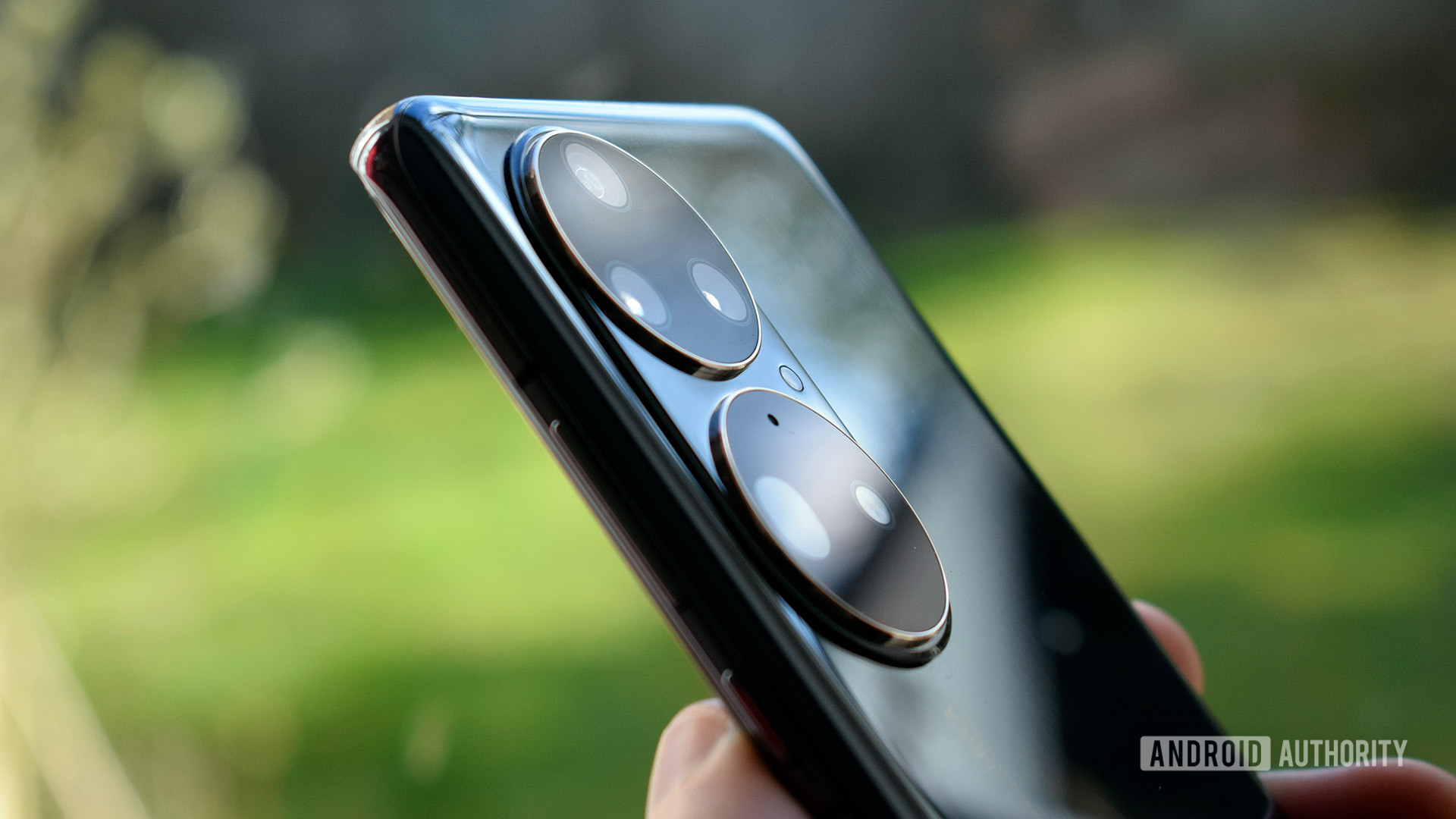 HUAWEI P50 Pro camera housing up close up in hand, taken outdoors with a green background