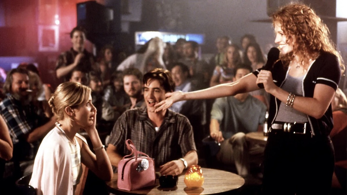 Cameron Diaz, Julia Roberts, and Dermot Mulroney at a karaoke bar in My Best Friends Wedding - best funny movies on netflix