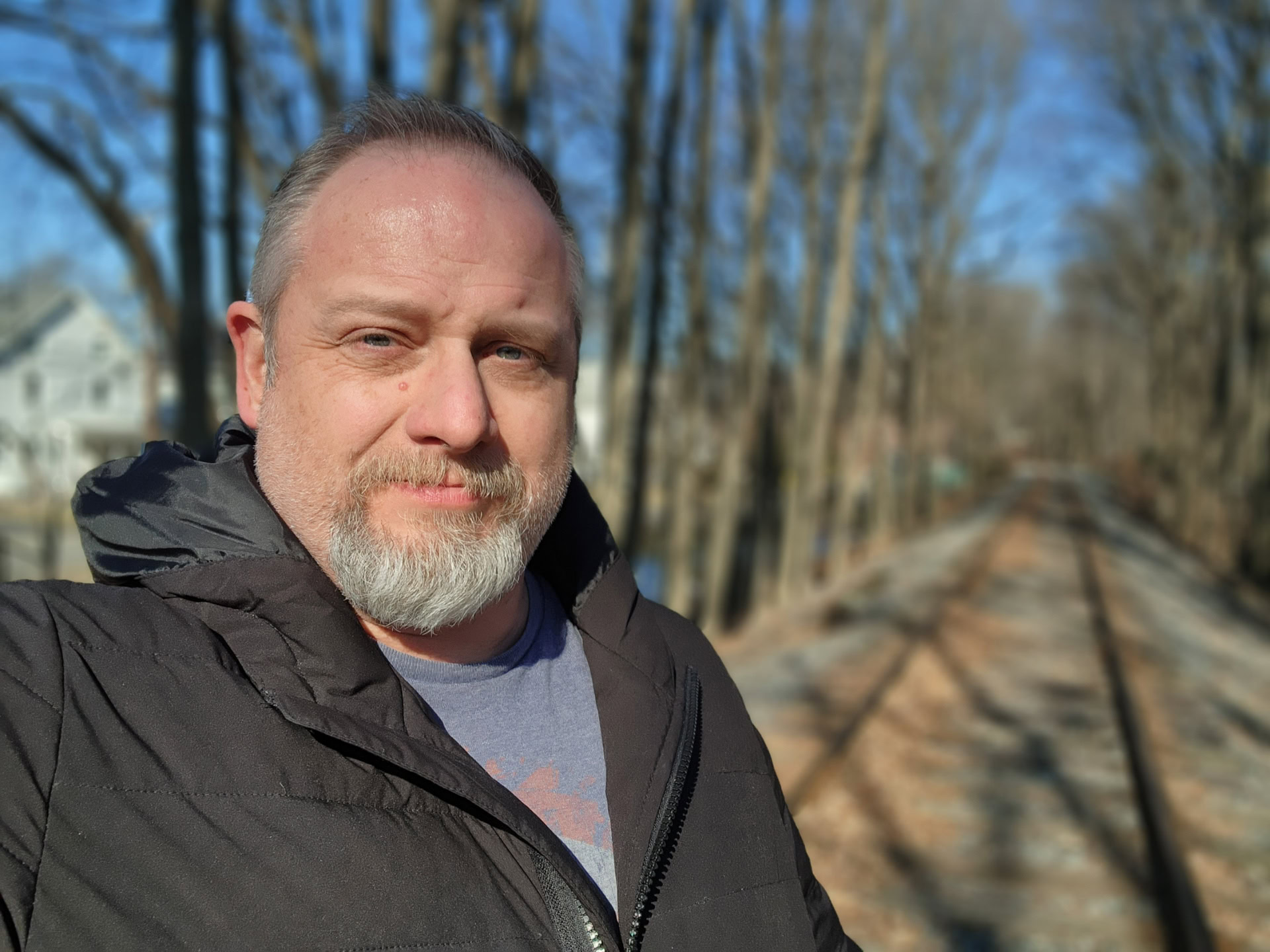 Samsung Galaxy S22 Ultra photo sample selfie portrait of a man with a grey beard outside wearing a grey t-shirt and black jacket.