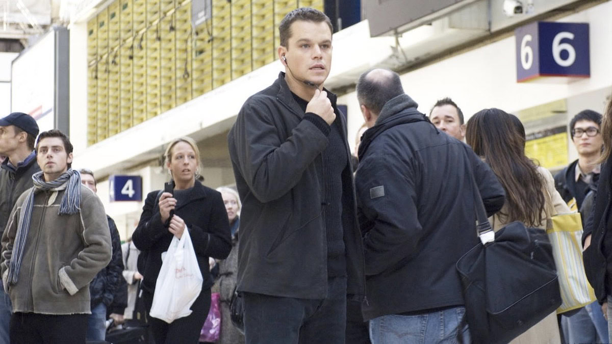 Matt Damon in a train station, speaking into a wireless headset in The Bourne Ultimatum