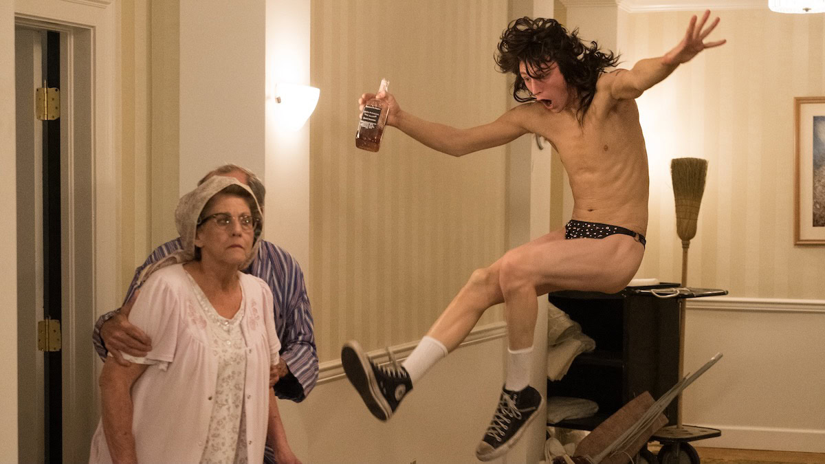 A drunk Tommy Lee jumpkicks in his underwear in a hotel hallway in The Dirt — movies like Pam and Tommy