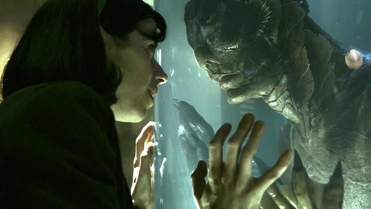 Sally Hawkins looks into a tank, where a fish man played by Doug Jones looks back at her in The Shape of Water