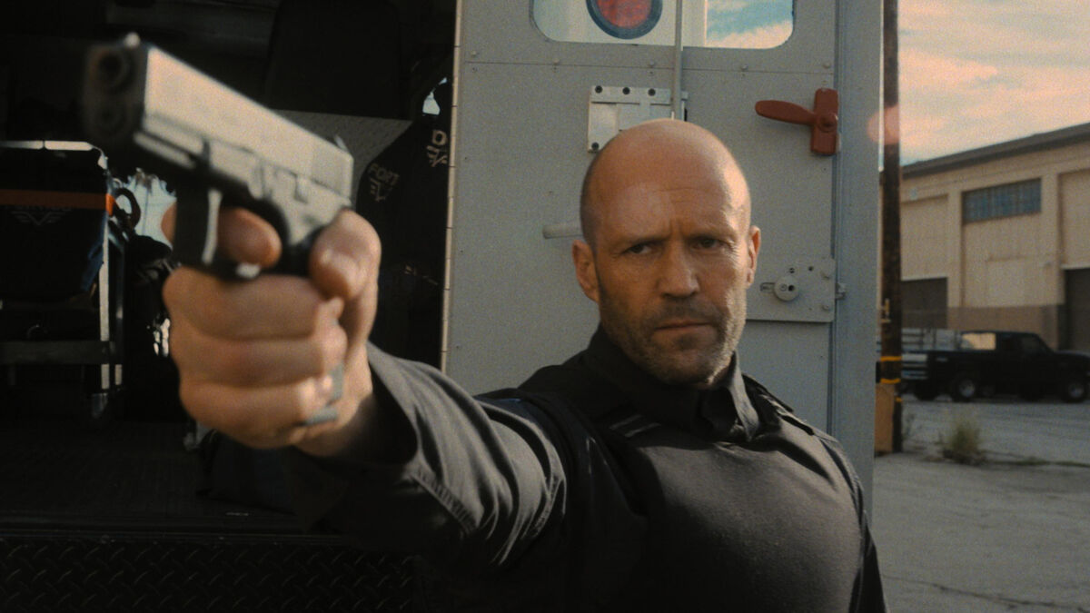 Jason Statham holding a gun in The Wrath of Man - new on Hulu in