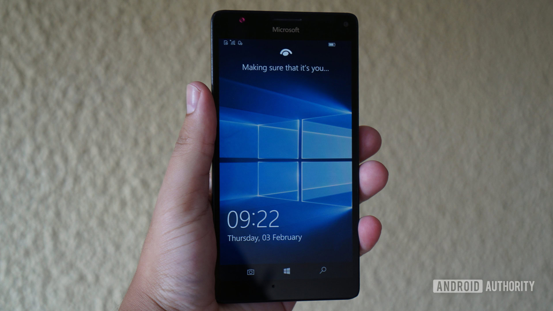 Windows 10 Mobile lockscreen on phone in hand