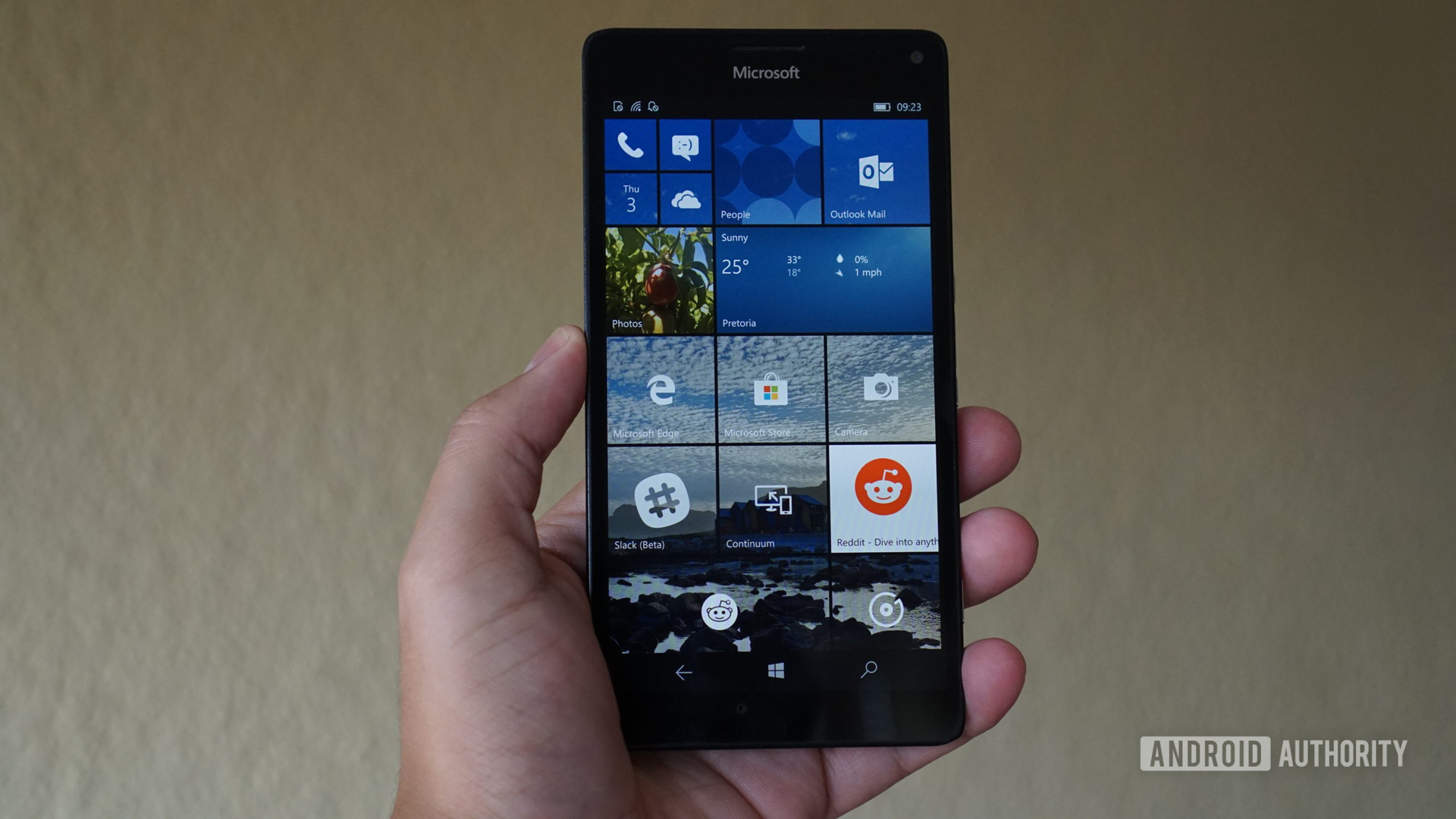 Windows 10 Mobile start screen on phone in hand