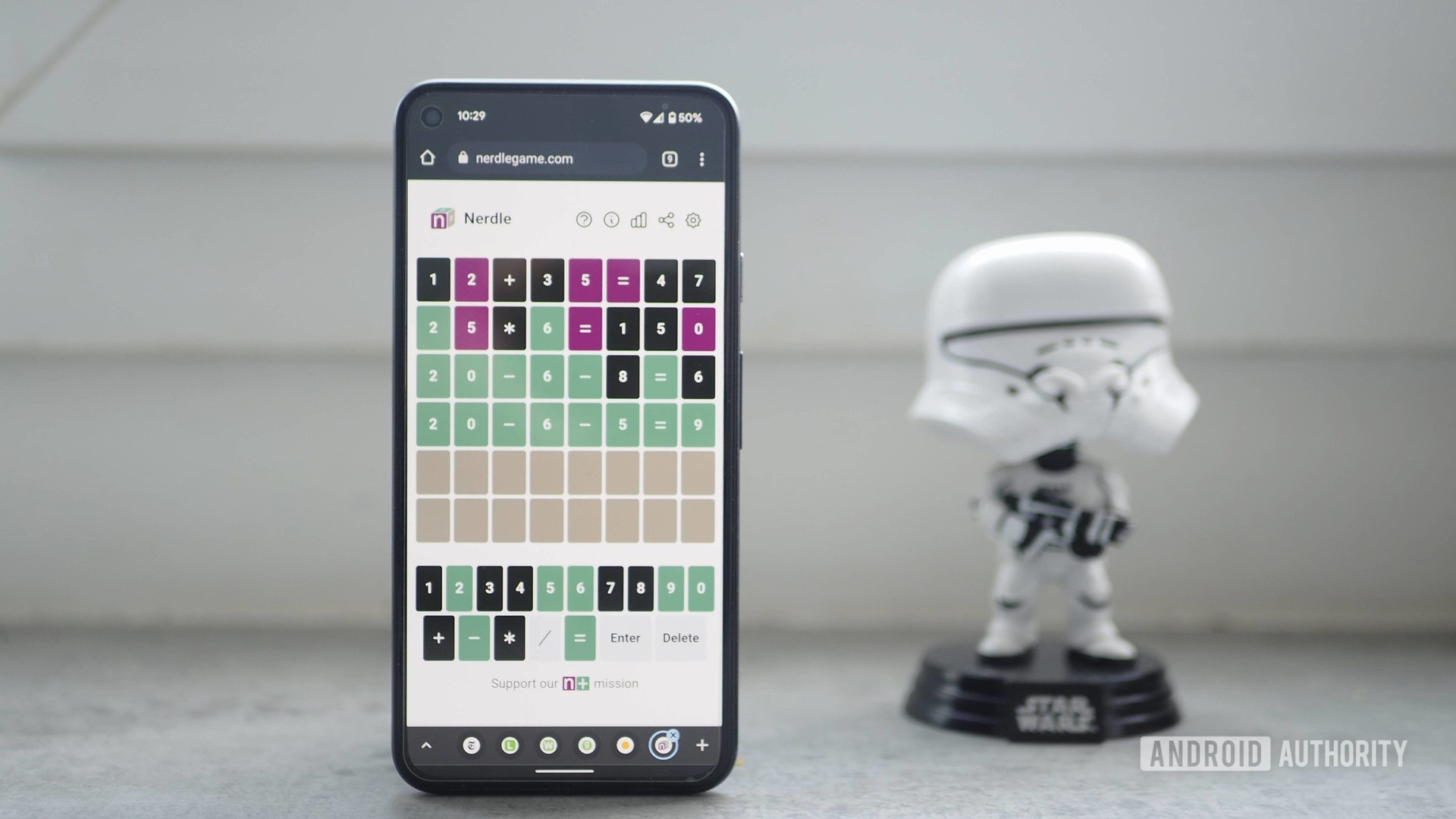 Pixel 5 showing Nerdlegame, a Wordle alternative, with a Star Wars figurine in the background