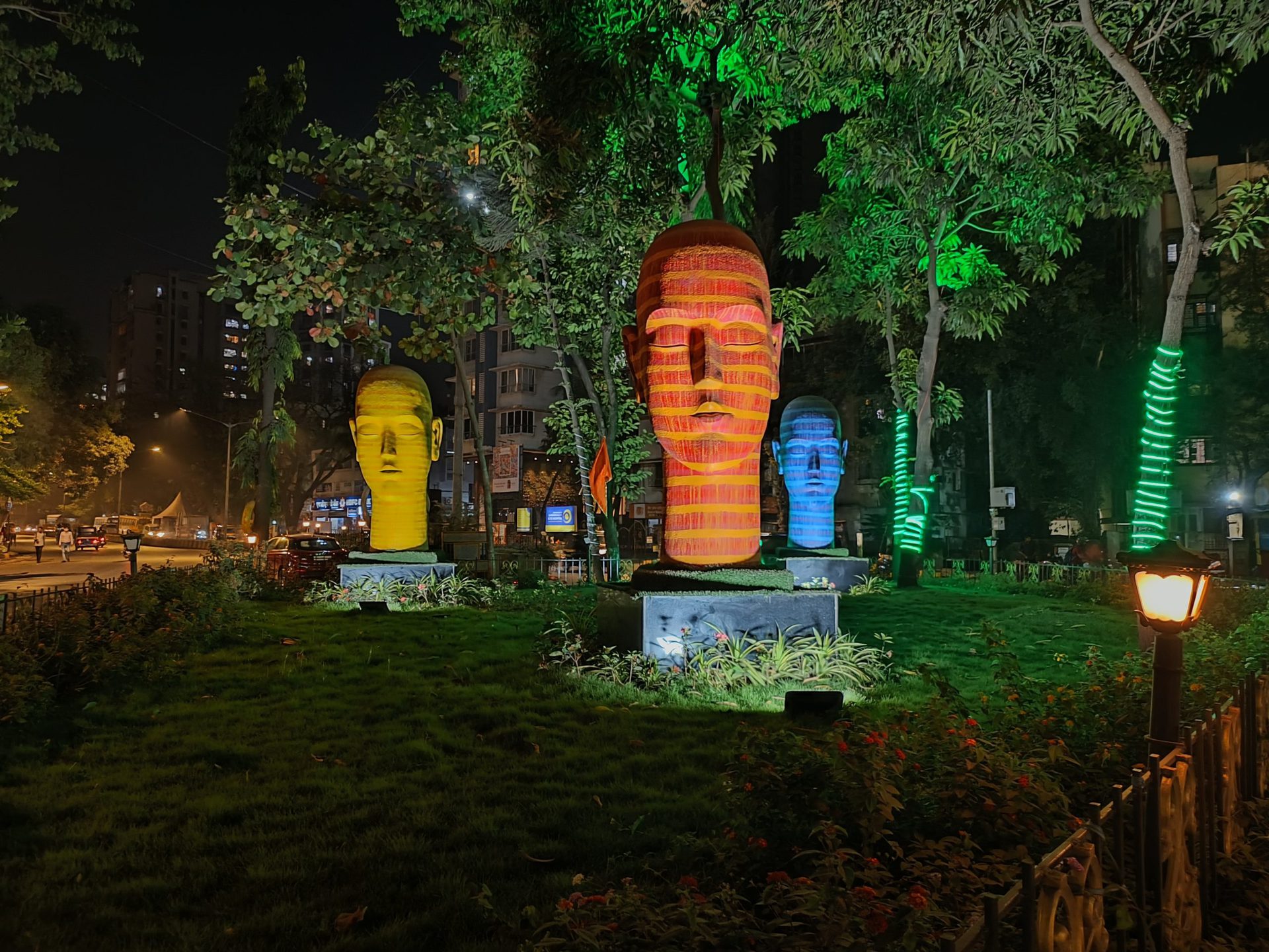 oppo reno 7 pro camera sample outdoors at night showing multicolored head sculptures in a park