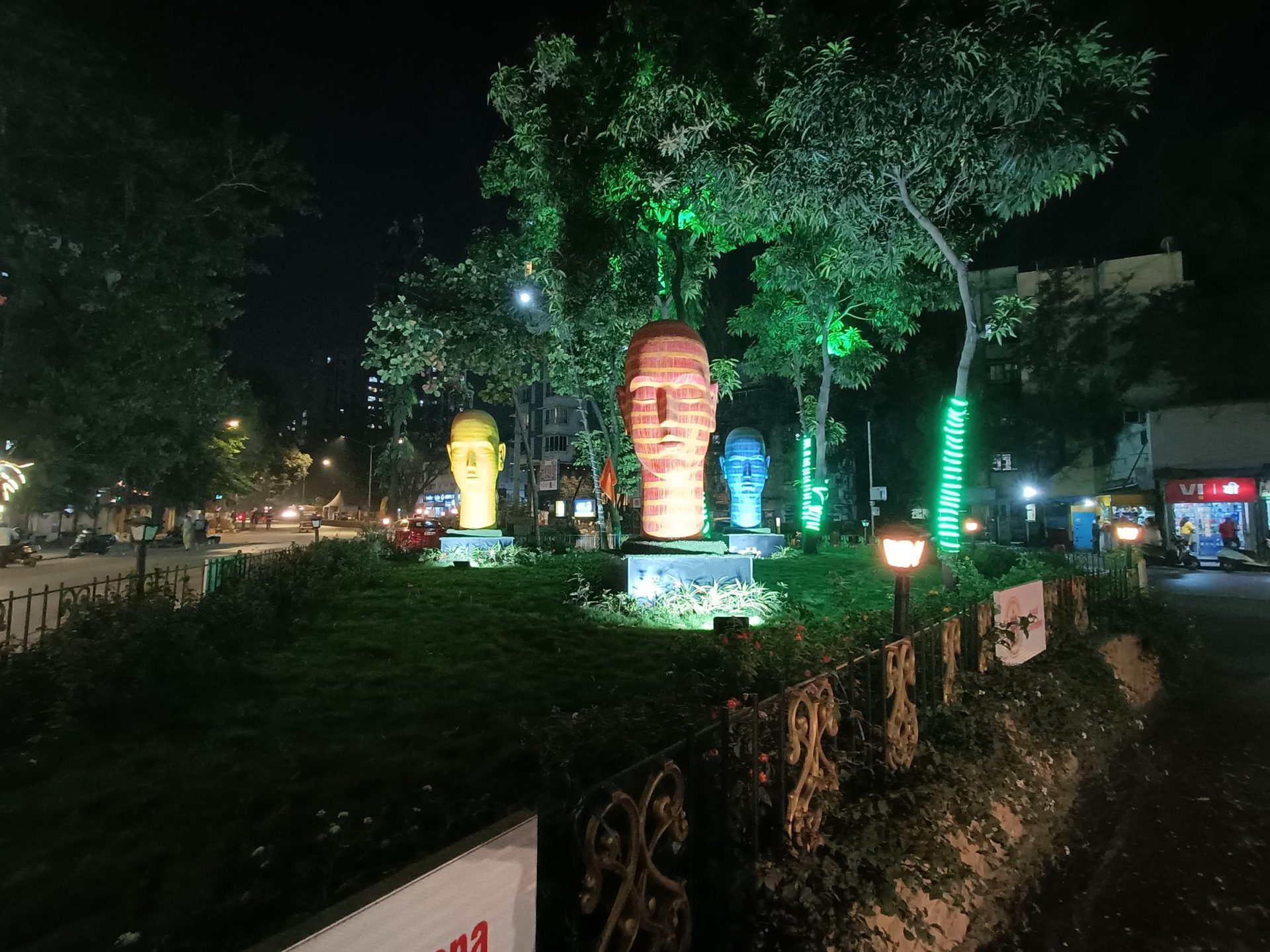 oppo reno 7 pro camera sample ultrawide image without night mode outdoors showing colorful head sculptures in a park