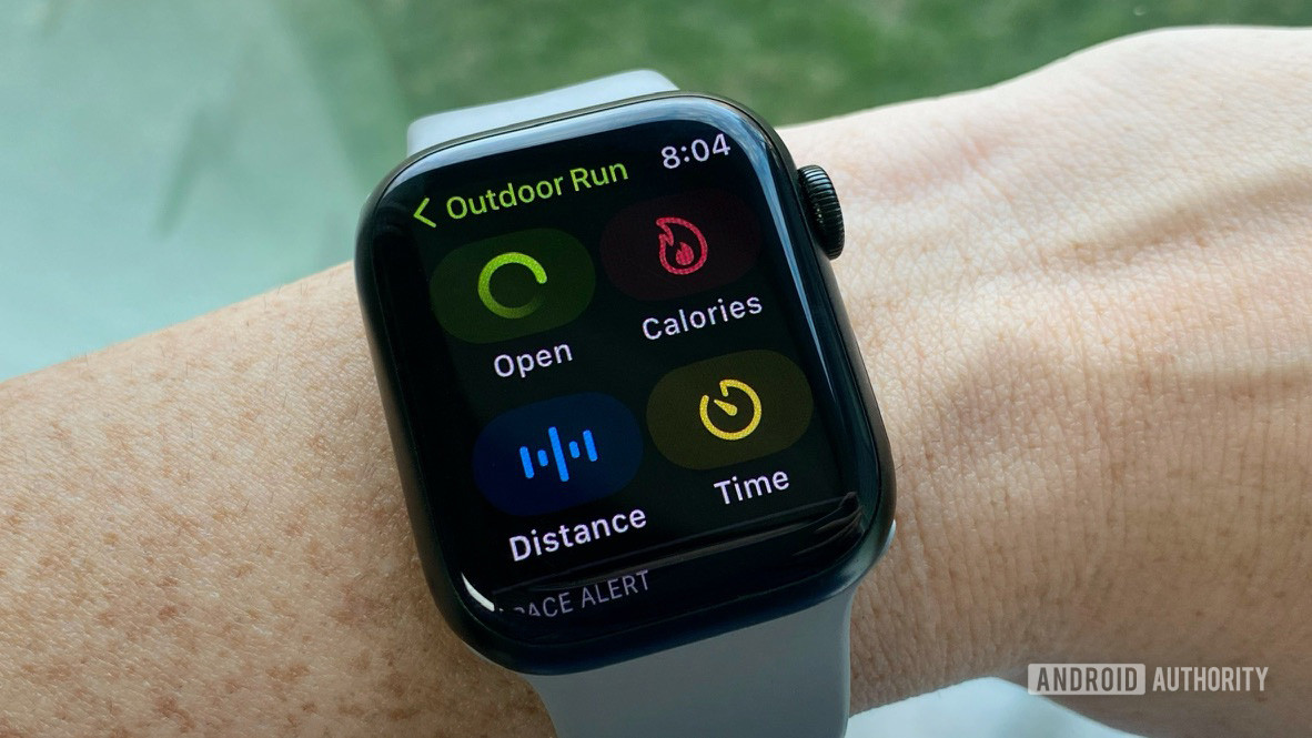 Bir kullanıcının bileğindeki Apple Watch Series 7, Outdoor Run ayarları ekranını görüntüler.