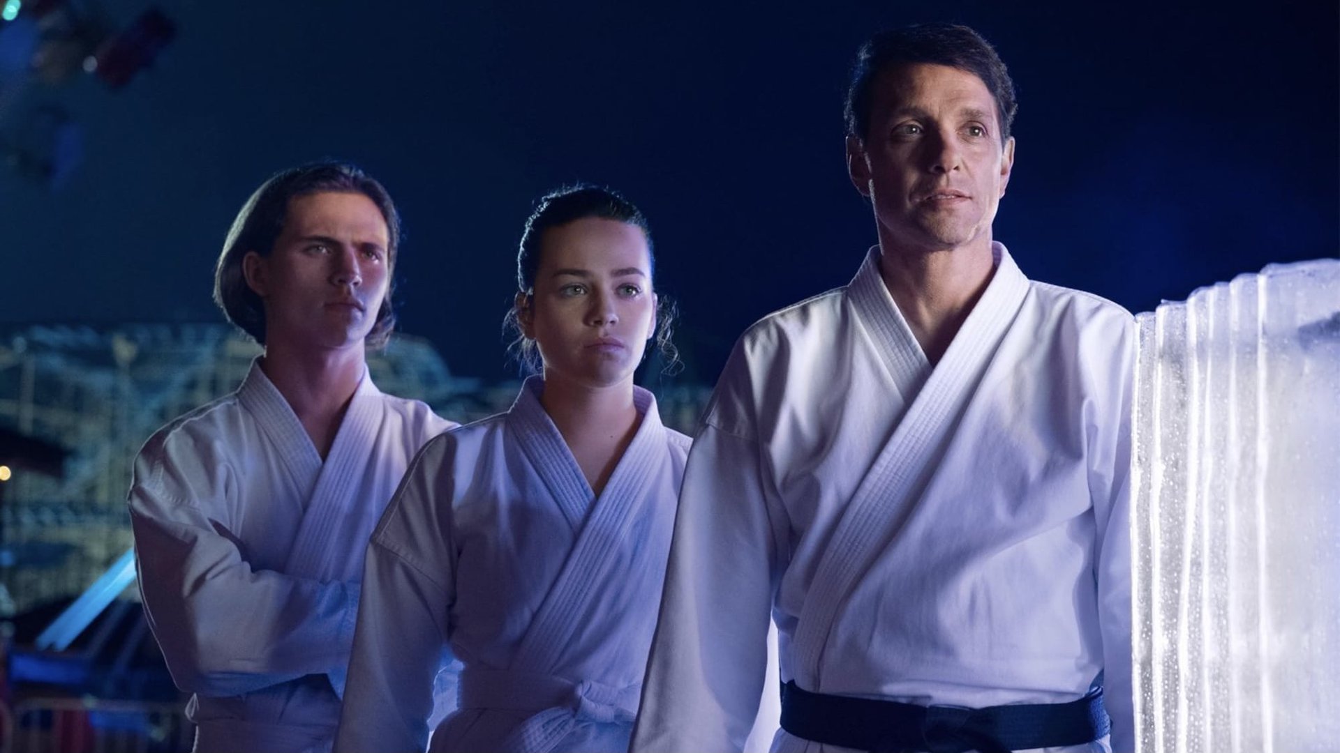 Ralph Macchio, Tanner Buchanan and Mary Muser stand together in Cobra Kai - best youtube originals