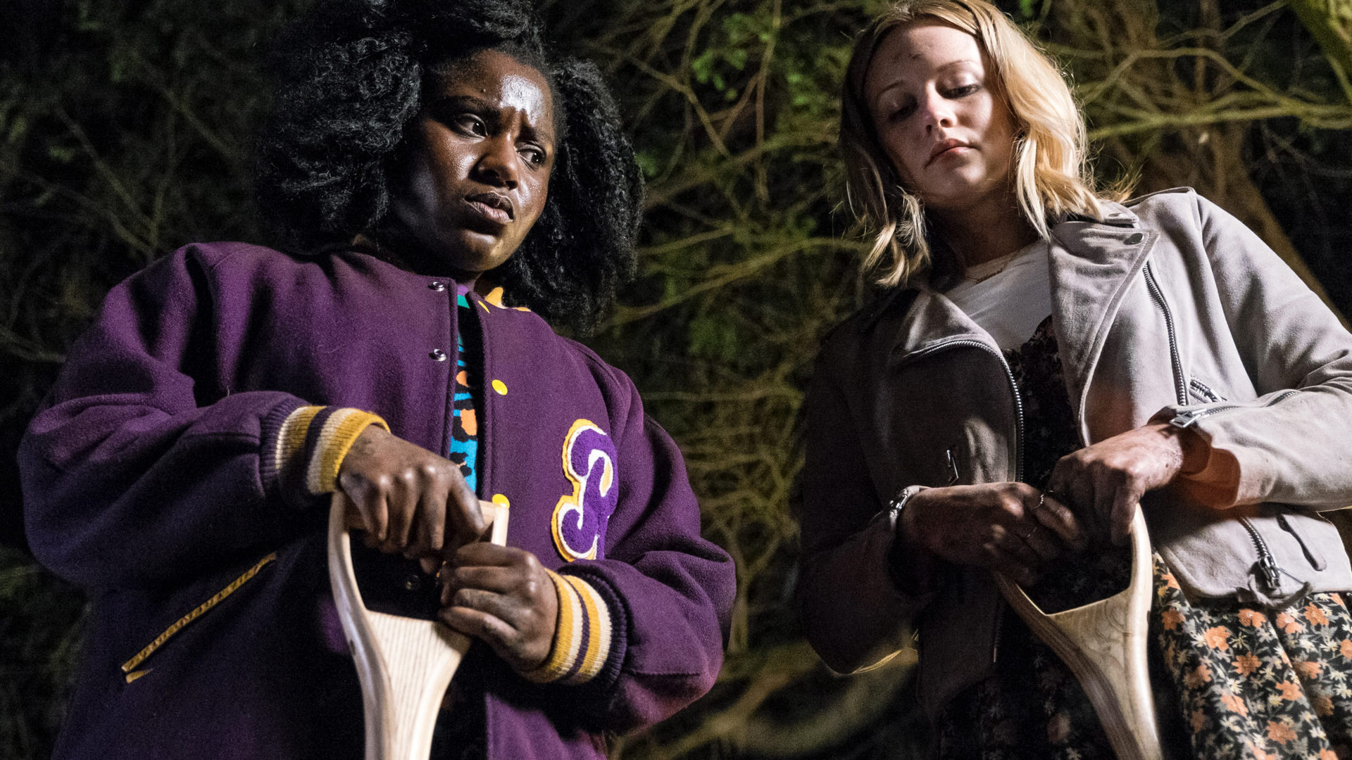 Susan Wokoma and Cara Theobold hold shovels at night in Crazyhead - best british shows on netflix