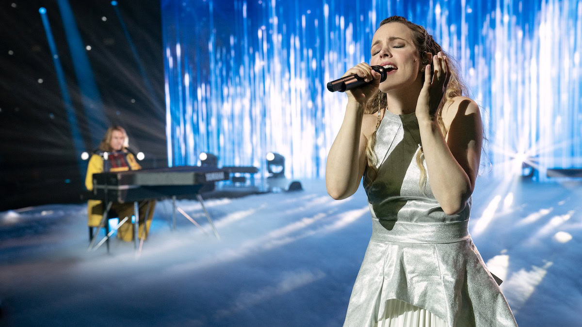 Rachel McAdams as Sigrit Ericksdottir singing, with Will Ferrell in the background at the piano in Eurovision Song Contest the Story of Fire Saga - best netflix comedies