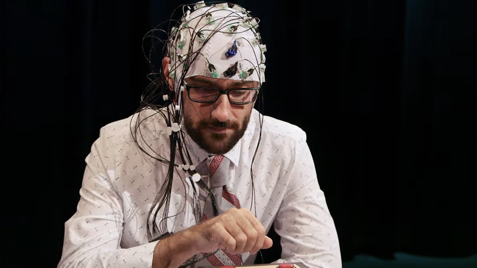 A man wears a helmet full of electrodes and sensors in Mind Field