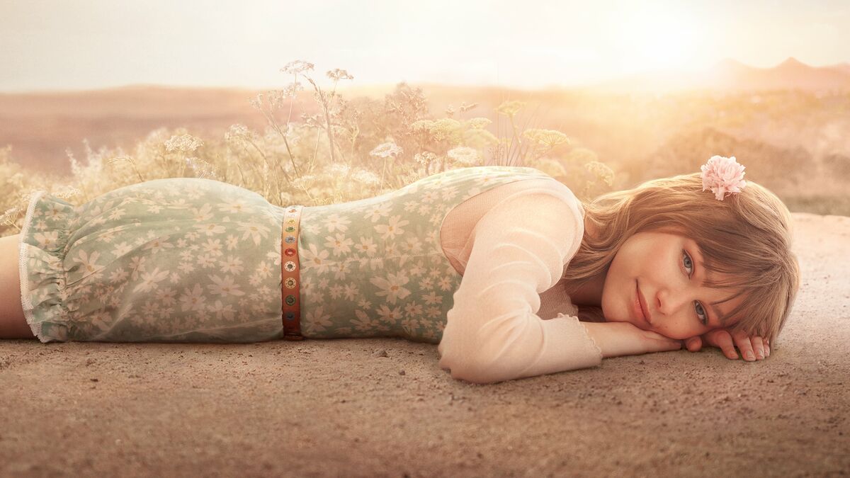 Girl lying down and facing the camera smiling in Star Girl