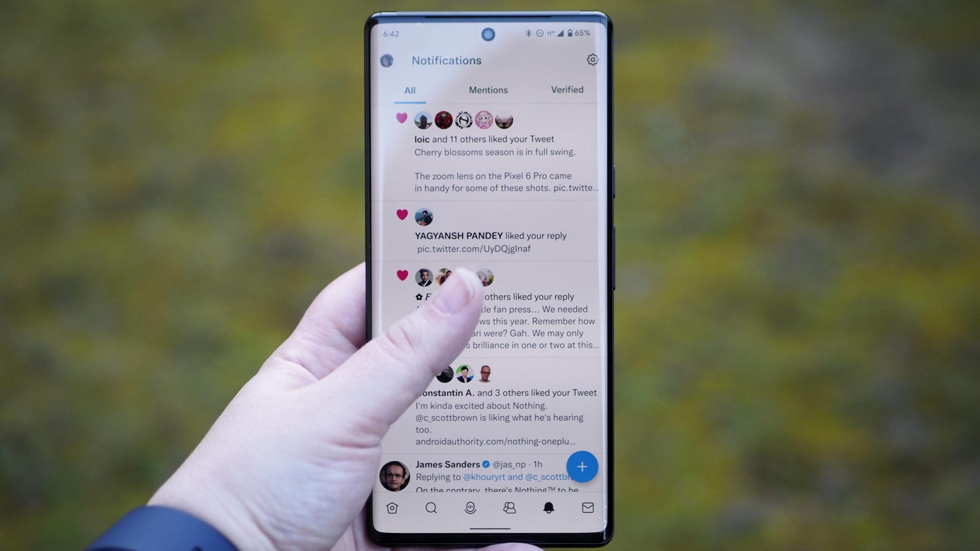 Google Pixel 6 Pro in front of Twitter with a visible thumb