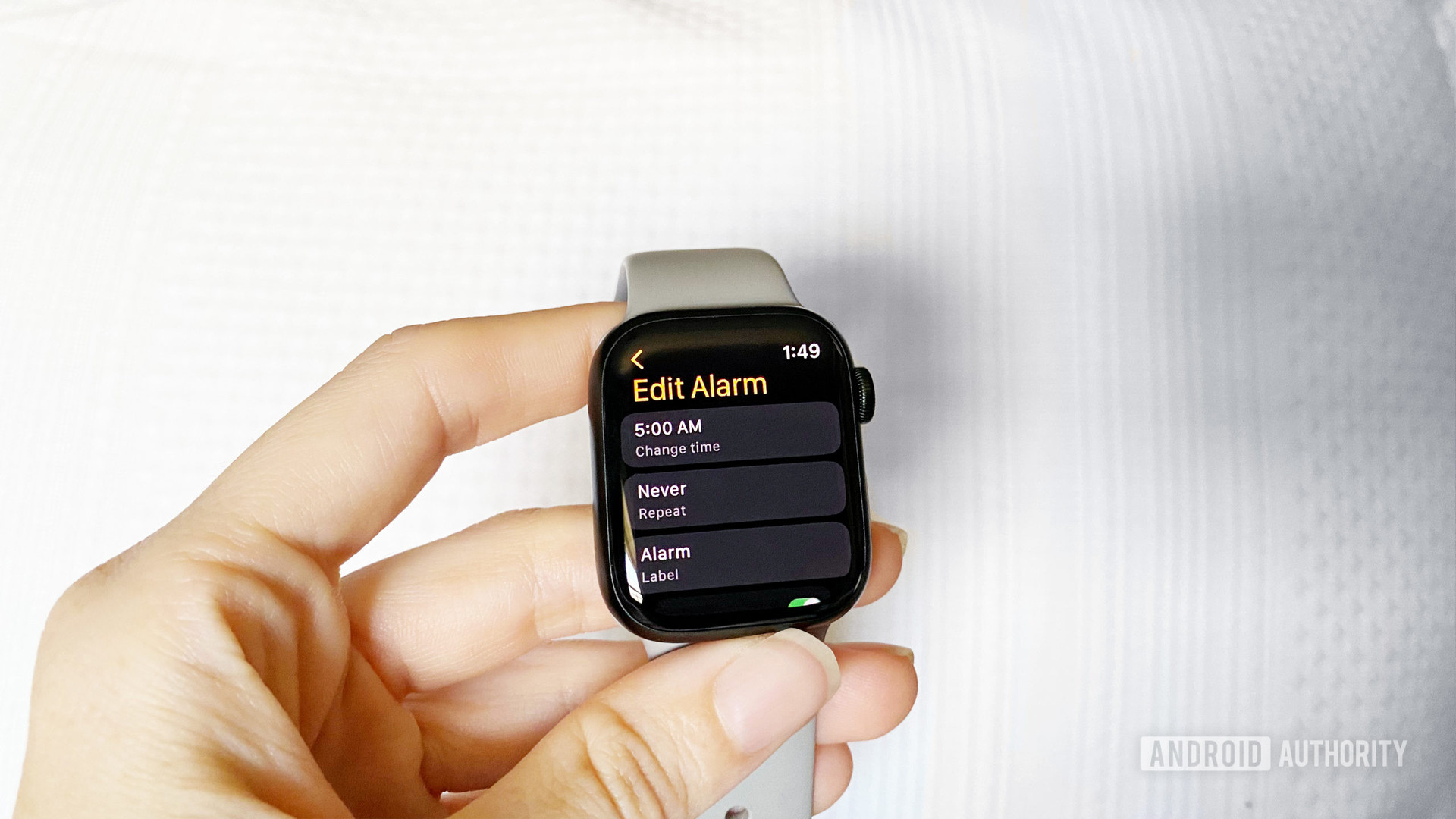 An Apple Watch Series 7 user edits an existing alarm on her watch.