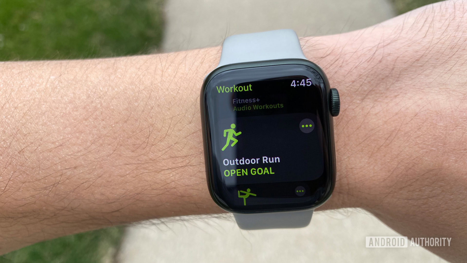 An Apple Watch Series 7 on a user's wrist displays the Outdoor Run screen