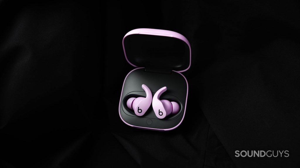 Beats Fit Pro earbuds in their case against a black background.