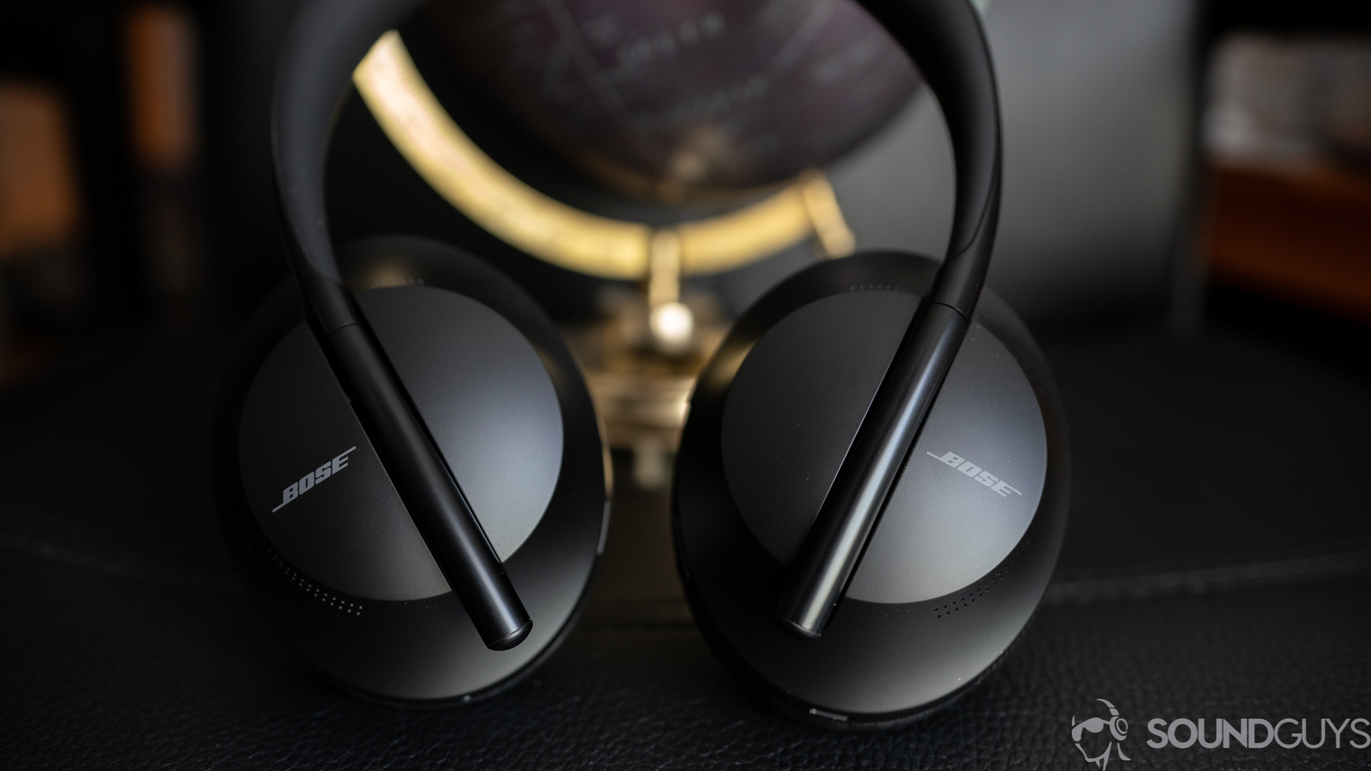 Bose Noise Canceling 700 headphones on a black surface.