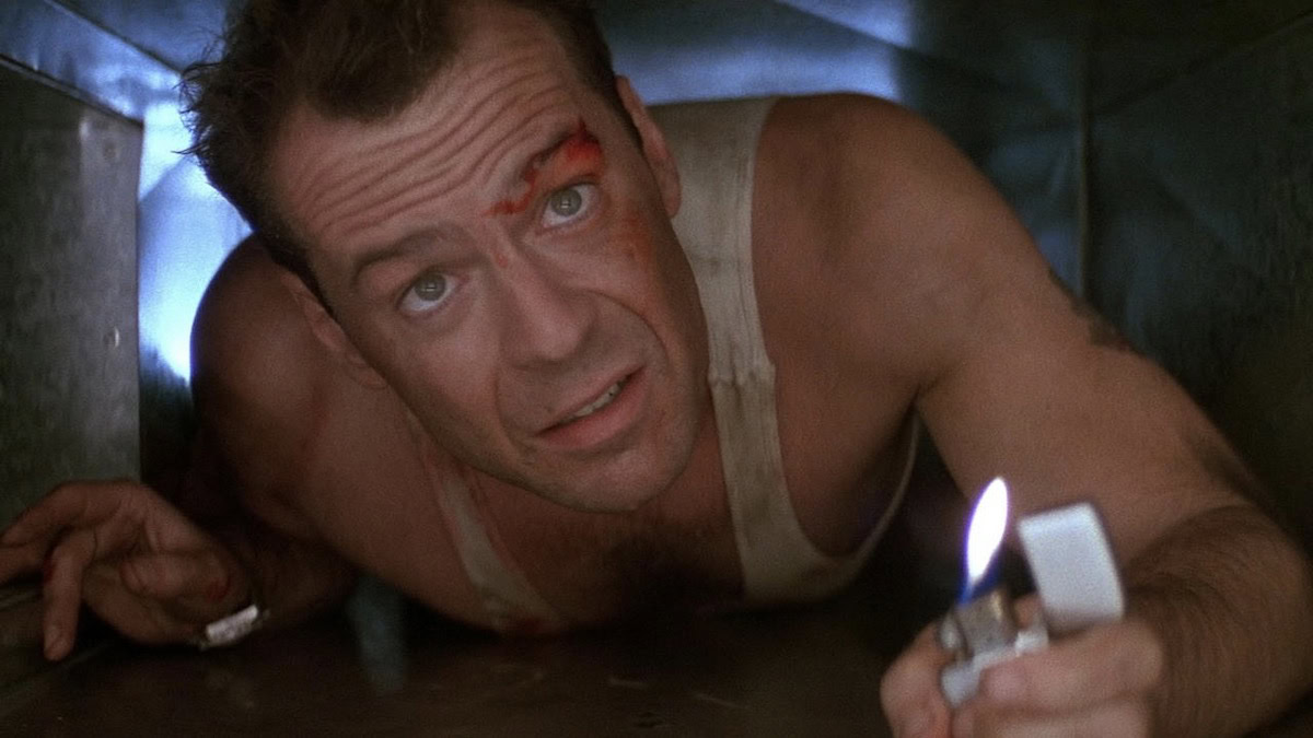 Bruce Willis se arrastra en un respiradero con un encendedor en Die Hard - mejores películas de bruce willis