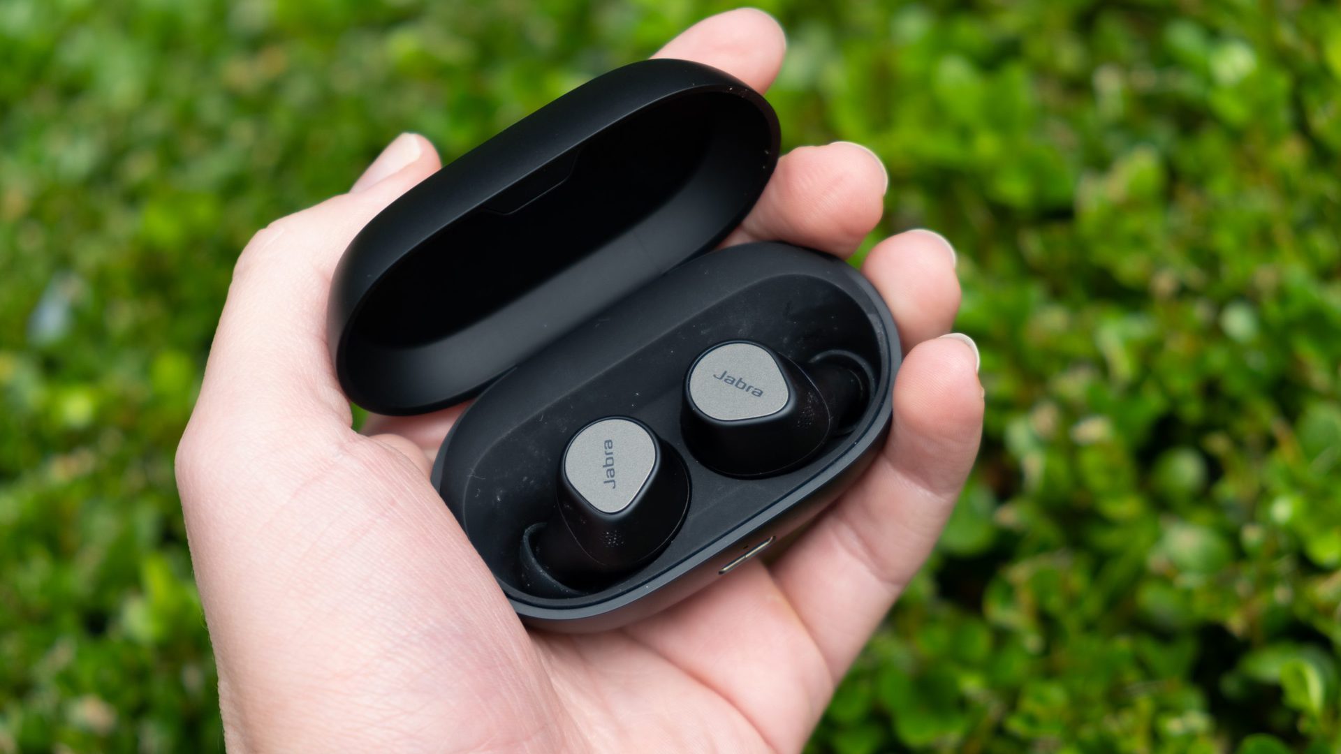 Jabra Elite 7 Pro in a hand in their case