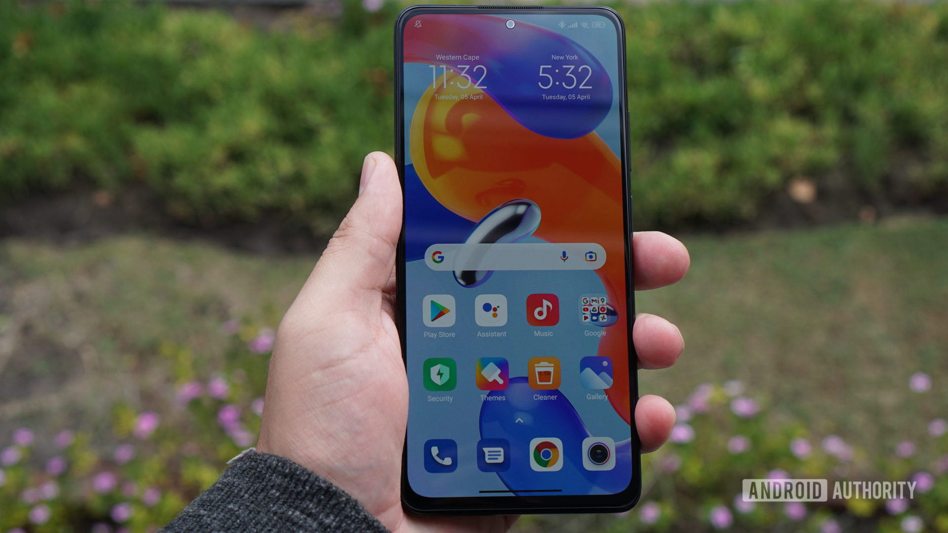 Redmi Note 11 Pro in hand showing screen outdoors