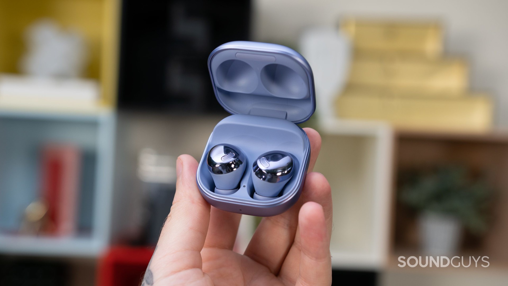 A hand holding up the open charging case for the Samsung Galaxy Buds Pro.