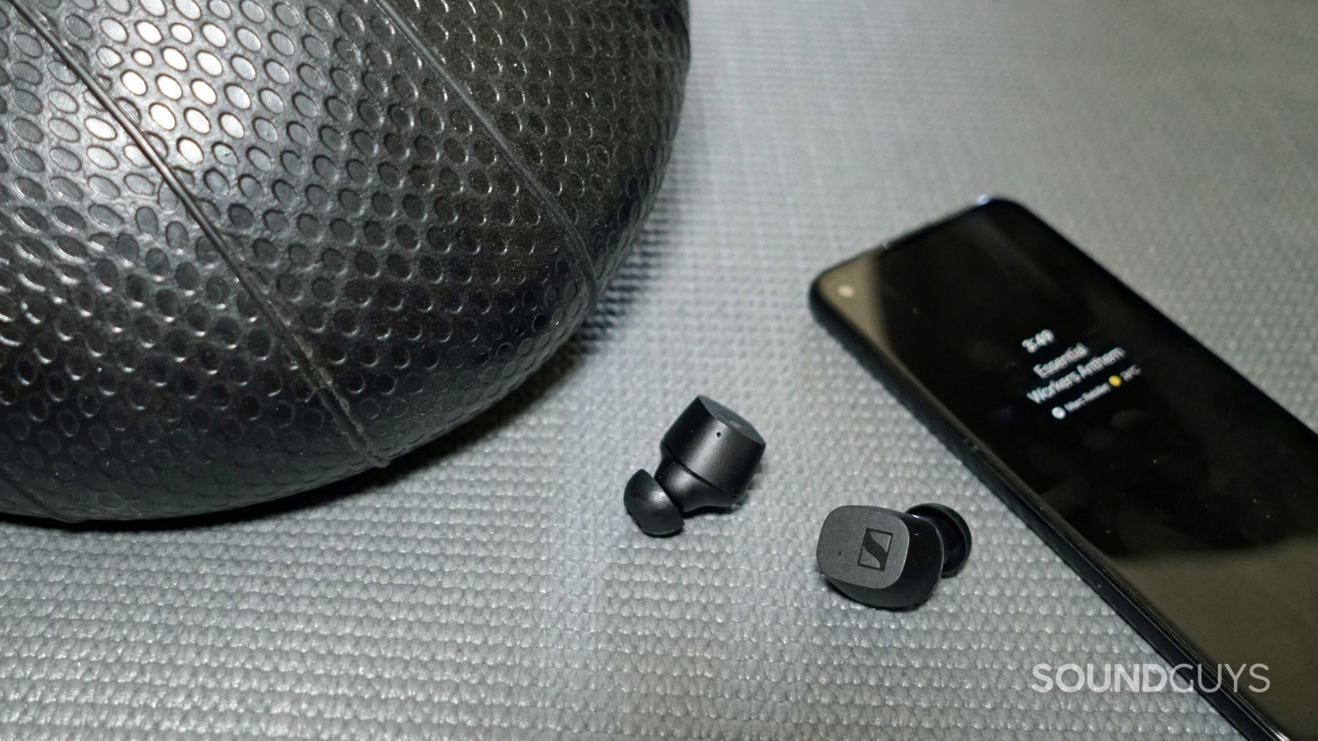 Sennheiser CX True Wireless earbuds next to a phone.