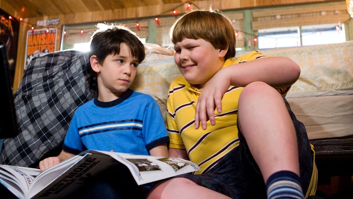 Two kids reading a magazine on the floor in diary of a wimpy kid - best disney plus kids movies