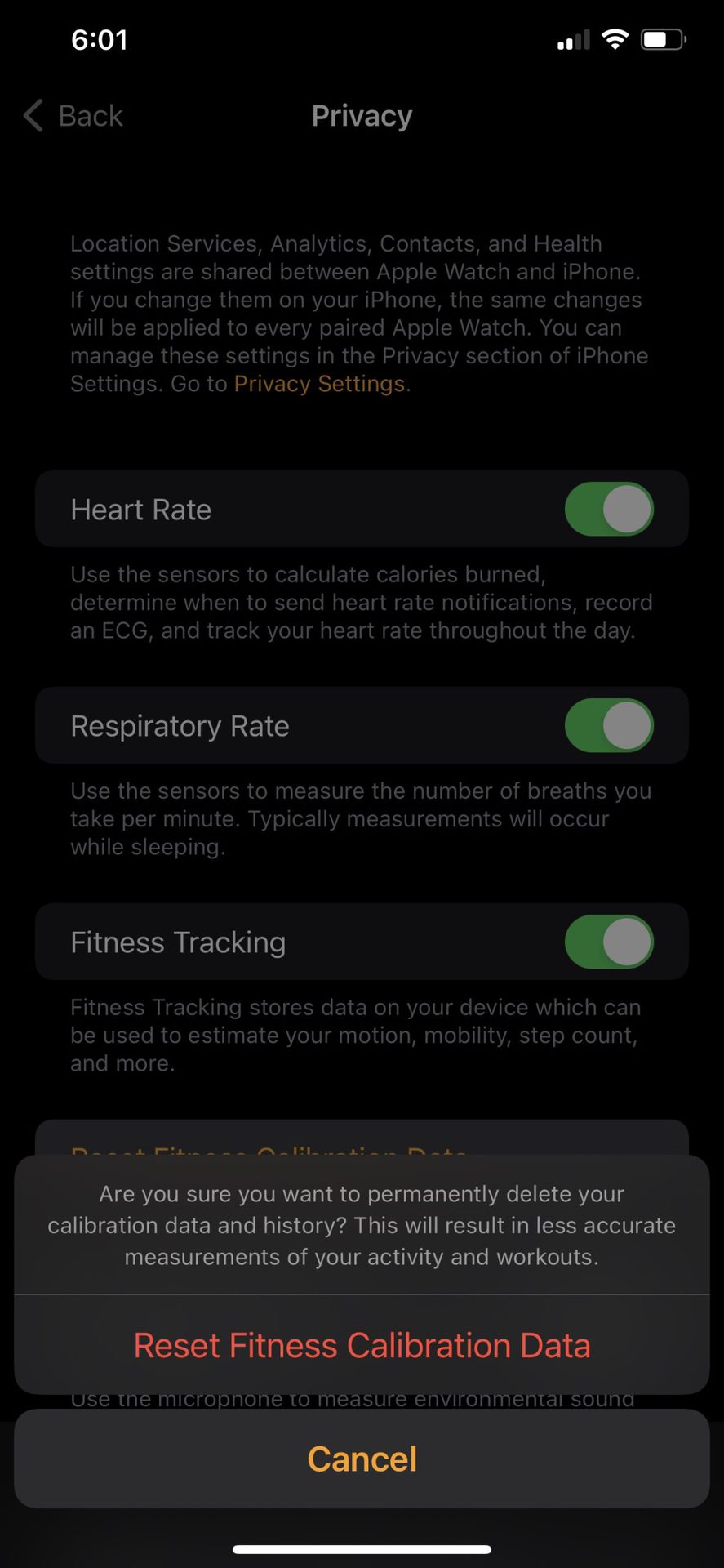 An iPhone 11 screenshot depicts a confirmation request to reset a users Apple Watch calibration.